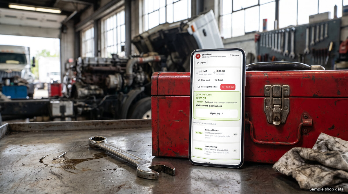 SendWrench technician portal on a phone propped against a red toolbox on a workbench, clocked onto a repair order